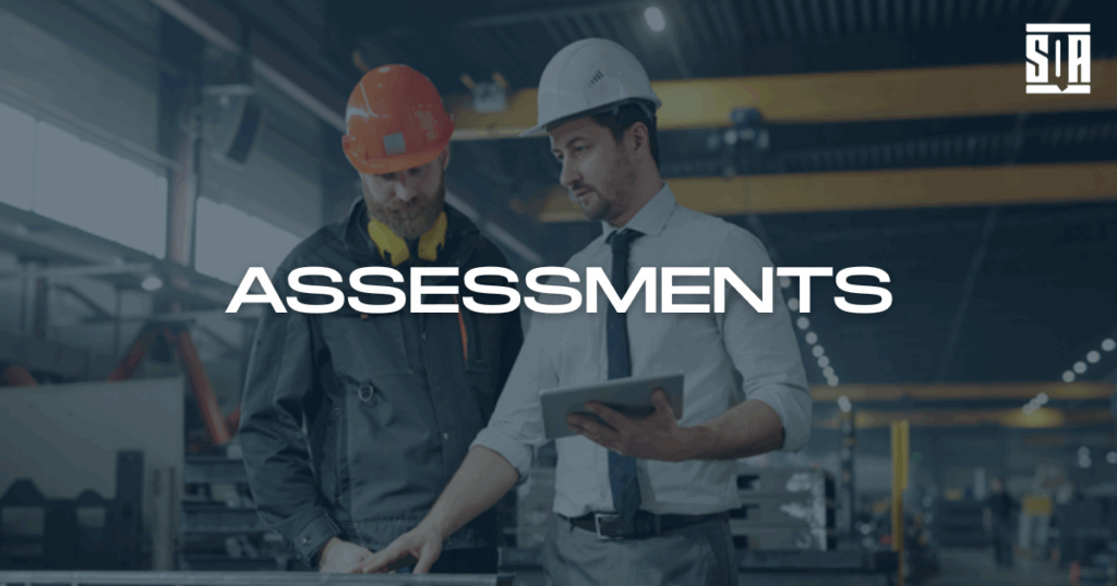 Two engineers in safety helmets reviewing assessment data on a tablet inside an industrial facility, with the word ‘ASSESSMENTS’ and SQA Services logo overlaid.